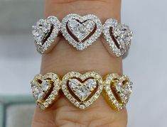 three heart shaped diamond rings sitting on top of someone's finger in front of the camera