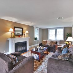 a living room with two couches and a fire place in it's center