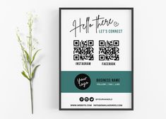 a business card with a qr code on it next to a plant and a white wall