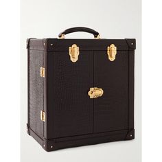 a black suitcase with gold handles on the top and bottom, sitting in front of a white background