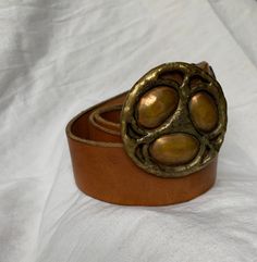 "You are looking at a genuine tan leather belt with two tone brass buckle. Belt measures 38\"2 long with 29\"7 from the first perforation and 36\"7 at it's last perforation from buckle and 1\"6 wide. The condition of this belt is good and is made of tan leather with great detail in buckle. The leather belt is thick and strong and there was a last perforation on end and the buckle is custom made. ------------------------------------I SHIP WORLDWIDE------------------------------------------------- Vintage Adjustable Gold Belt, Vintage Leather Belt With Brass Buckle, Vintage Leather Adjustable Belt Buckles, Adjustable Brown Belt With Brass Buckle, Vintage Brown Belt Buckles With Brass Buckle, Vintage Adjustable Belt Buckles With Brass Buckle, Vintage Brown Belt Buckle With Antique Detail, Retro Adjustable Belt Buckles With Antique Buckle, Retro Leather Belt Buckles