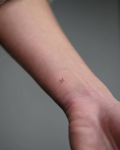 a person's arm with a small tattoo on it