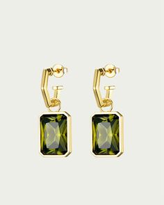 Easy and elegant earrings to complement any outfit. The 'Volt Gemstone Statement Earrings' are an eye-catching styling essential, featuring a large square faceted peridot nano-gemstone, suspended from a modern angular hoop. Sold as a pair for pierced ears.Diameter: .59 (15mm) hoops, 1.4 (35mm) total dropDetails: 18K gold plated brass, peridot nano-gemstones Instantly elevate your fave plus size dresses and tops with the perfect piece of jewelry F+H Studios Volt Gemstone Statement Earrings in Gold/Green | Gold/Green | Accessories | Materials & Care Instructions: ['Nickel free', 'Imported'] Modern Jewelry With Rectangular May Birthstone, Modern Rectangular May Birthstone Jewelry, Modern Earrings With May Birthstone Gemstone, Modern Green Earrings For May Birthstone, Rectangular Gemstone Earrings For May Birthstone, Modern Green May Birthstone Earrings, F H, Green Accessories, Earrings In Gold