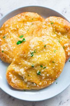 two cheese muffins on a white plate with parmesan sprinkles