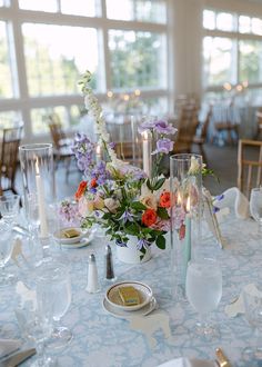 Colorful Cape Cod wedding centerpieces. The image shows the colorful centerpieces on a table which has a light blue patterned table linen with colorful taper candles and cane table numbers. The table is in the reception space at the Coonamesset on Cape Cod, a Falmouth wedding venue. Colorful Wedding Centerpieces, Colorful Summer Wedding, Cape Cod Wedding, Summer Wedding Colors, Pink Orchids, Unique Flower, Colorful Wedding, Unique Flowers, Taper Candles