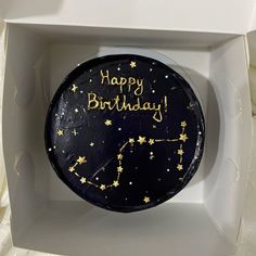 a black and gold birthday cake in a white box