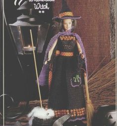 a crocheted witch doll is posed with her broom and hat in front of a halloween scene