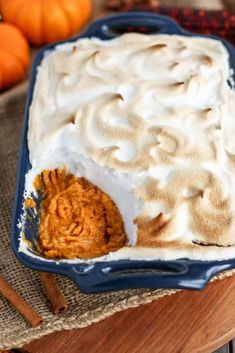 a dish with whipped cream and pumpkins in the background