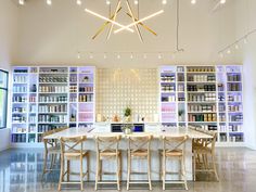 a dining room table with chairs and bookshelves in the background