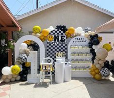 a birthday party with balloons and decorations in the shape of smiley face, checkered table cloths