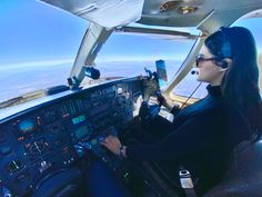 a woman sitting in the cockpit of an airplane