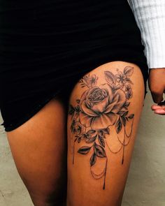 a woman's thigh with a rose tattoo on it