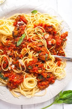 a white plate topped with spaghetti and meat sauce