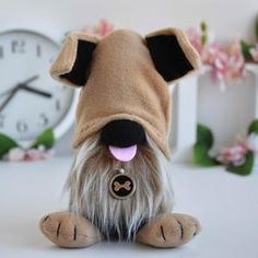 a small stuffed dog sitting next to a clock