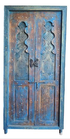 an old wooden door with intricate carvings on the front and side doors, all painted blue