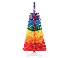 a multicolored christmas tree on a white stand