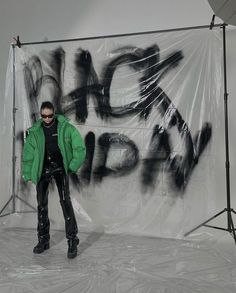 a man standing in front of a graffiti covered wall