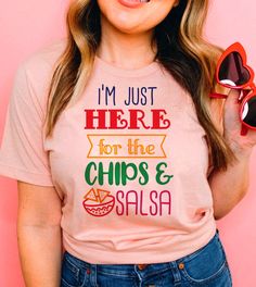 This "I'm Just Here For The Chips & Salsa" design is the perfect, fun Cinco De Mayo shirt for anyone that loves drinks and to celebrate! Novelty Screen Print Summer Tops, Novelty Screen Print Tops For Summer, Fun Slogan Crew Neck Top, Pink Tops With Funny Text, Cinco De Mayo Funny Print Crew Neck T-shirt, Fun Pink Shirt With Funny Text, Cinco De Mayo Funny Print Crew Neck Top, Fun Graphic Print T-shirt For Cinco De Mayo, Novelty Crew Neck Top With Funny Text