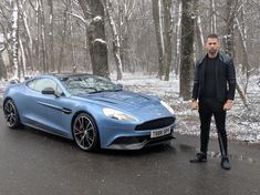 a man standing next to a blue sports car