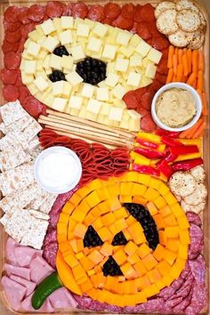 a platter filled with cheese, crackers and other food items including meats