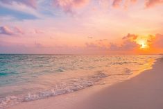 the sun is setting over the ocean and beach with waves coming in to shore,