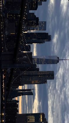 an image of the city skyline at night from across the water with clouds in the sky