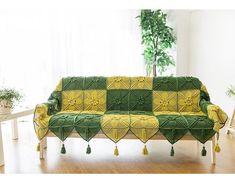 a couch covered in green and yellow crochet