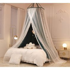 a canopy bed with white sheets and pillows