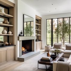 a living room filled with furniture and a fire place in front of a large window