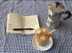 an open book sitting on top of a table next to a drink