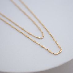 the namesake of our shape of you collection, this necklace embodies the concept behind the collection: taking it back to basics with simple, everyday, elevated pieces. 18kt gold BR gold filled available in 16" or 18" in length Minimalist 14k Gold Filled Charm Necklace For Layering, Minimalist Double Strand Layered Necklace, Everyday 14k Gold Filled Charm Necklace With Satellite Chain, Modern Double Strand Everyday Necklaces, Minimalist 14k Gold Filled Layered Necklace For Everyday, Minimalist 14k Gold-filled Charm Necklace With Delicate Chain, Modern Gold Necklaces For Everyday, Modern Double Strand Necklace For Everyday, Dainty Gold Necklace For Everyday Use