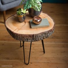 a wooden table with two potted plants on it and a book next to it