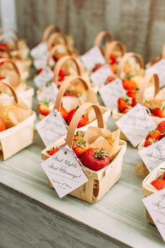 baskets filled with strawberries sitting on top of a table next to other small boxes