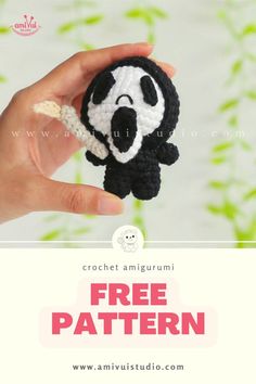 a hand holding a small crocheted panda bear in it's right hand