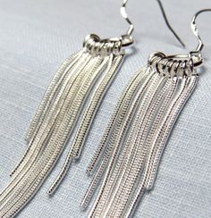 "Nine delicate silver \"ropes\" dangle from a small silver ring to form an exciting pair of earrings! These are made of sterling silver and have such a lovely, swaying movement to them. From the top of the ear wire to the longest chain, they are a little over 3\" long. Very light weight." Silver Dangle Threader Earrings For Party, Silver Dangle Threader Earrings, Silver Sterling Threader Earrings For Party, Silver Sterling Silver Threader Earrings For Party, Silver Metal Threader Earrings, Adjustable Nickel-free Silver Threader Earrings, Adjustable Nickel Free Silver Threader Earrings, Elegant Nickel Free Silver Threader Earrings, Elegant Nickel-free Silver Threader Earrings