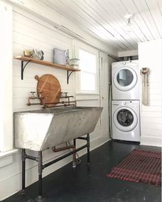 a washer and dryer in a small room with wood flooring on the walls