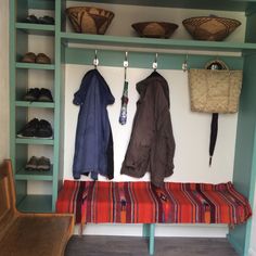 the coat rack is filled with coats and shoes, along with other items on display