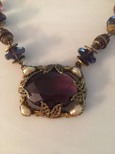 "Beautiful Art Nouveau amethyst glass and shell Pearl brass choker. Circa 1905 Necklace measure 14\" with a 1.5\" pendant. Probably Czech. Thank you !" Vintage Amethyst Purple Jewelry, Vintage Amethyst Pendant Jewelry, Collectible Amethyst Necklace In Purple, Collectible Amethyst Purple Necklace, Vintage Purple Amethyst Jewelry, Collectible Purple Amethyst Necklace, Purple Amethyst Necklace For Collectors, Vintage Gold Amethyst Necklace, Antique Handmade Amethyst Necklace