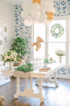 a dining room table with balloons hanging from it's ceiling and decorations on the wall