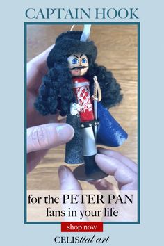 a hand holding a toy with the caption captain hook for the peter pan fans in your life shop now