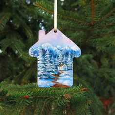 a house shaped ornament hanging from a christmas tree