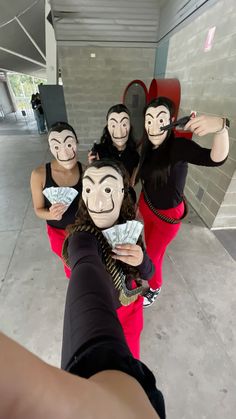 five people wearing masks and holding money in front of their faces while taking a selfie