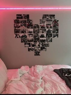 a bed with white sheets and pink comforter in front of a heart shaped wall