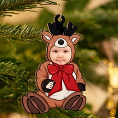 a christmas tree ornament with a little boy dressed as a reindeer hanging from it