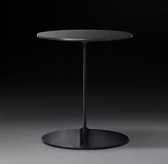 a round table with a black base on a dark background