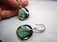 Sale, $25 off. Handmade, luxury pair of earrings comprised of stunning, rare oval green with blue hue Amethyst stones attached to sterling silver Pave ear wires studded with tiny, sparkling, diamond like CZ. Great gift for her, they will be a family heirloom for years to come. Gorgeous, AAAA+ quality stones measure : 1) 40 ct. total. Each stone is 23 x 12 x10 mm. As photo. Sold out. 2) 32 carats total, each 19 x 15 x 9 mm. 3) 52 carats, each stone is 23 x 20 mm. 4) 30 carats, each stone is 20x 1 Handmade Elegant Green Amethyst Jewelry, Elegant Handmade Green Amethyst Jewelry, Elegant Green Amethyst Earrings For Gift, Silver Green Amethyst Earrings For Gift, Green Amethyst Gemstone Earrings, Green Multi-stone Amethyst Jewelry, Elegant Faceted Green Amethyst Earrings, Luxury Green, Green Multi-stone Sterling Silver Earrings