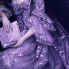 a woman in a purple dress holding a book