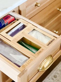 an open drawer in a kitchen with toothbrushes and other items on it's drawers