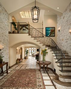 a large foyer with stairs leading up to the second floor and an area rug on the floor