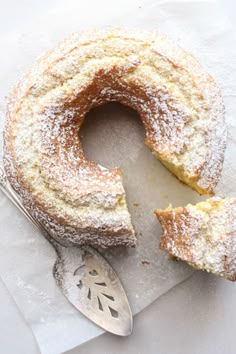 a piece of cake with powdered sugar on top and a spoon next to it